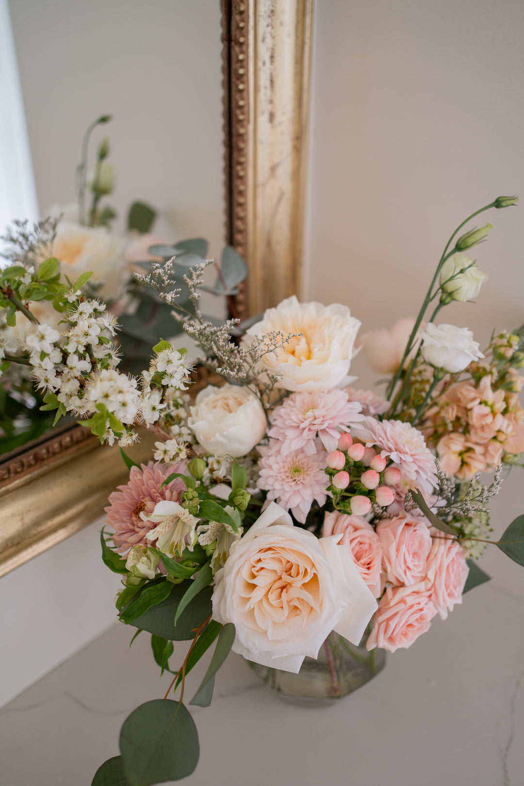 Bouquet of flowers on a table with a decorative mirror in the background